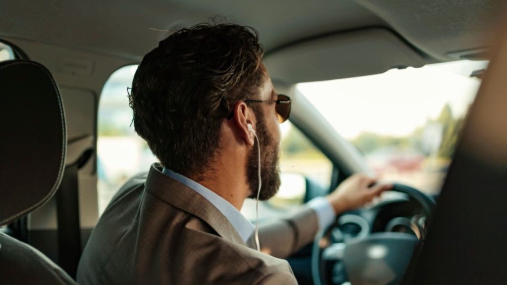businessman using headphones in the car